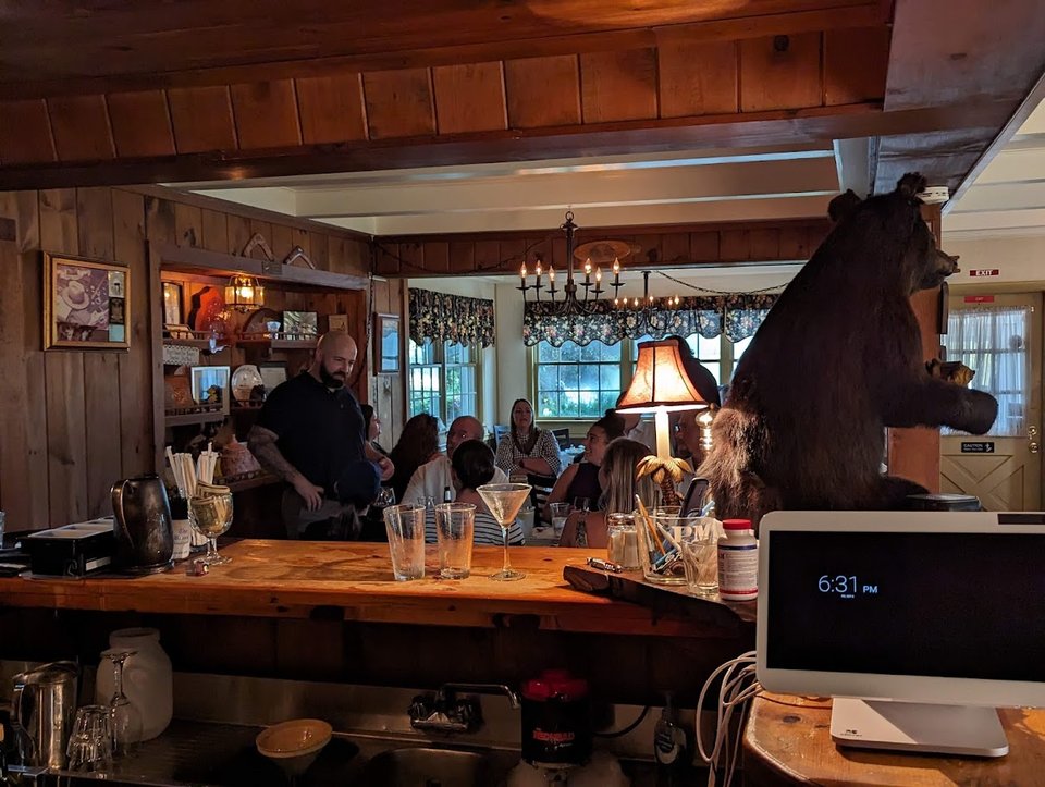 Dining room with dark wood tables and warm lighting.
